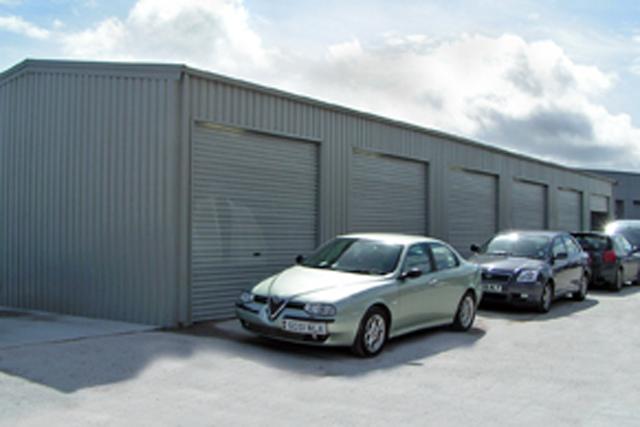 Multiple cars parked outside a long building